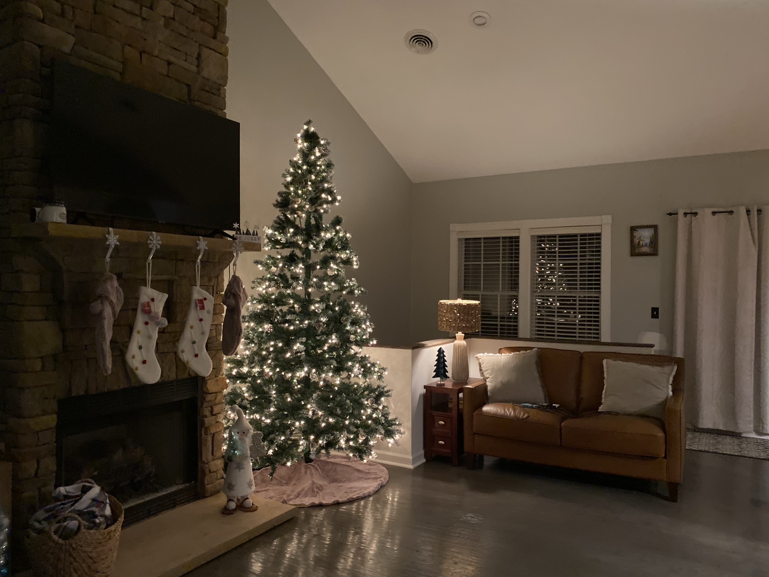 Christmas tree and stockings beside the stone fireplace in the living room
