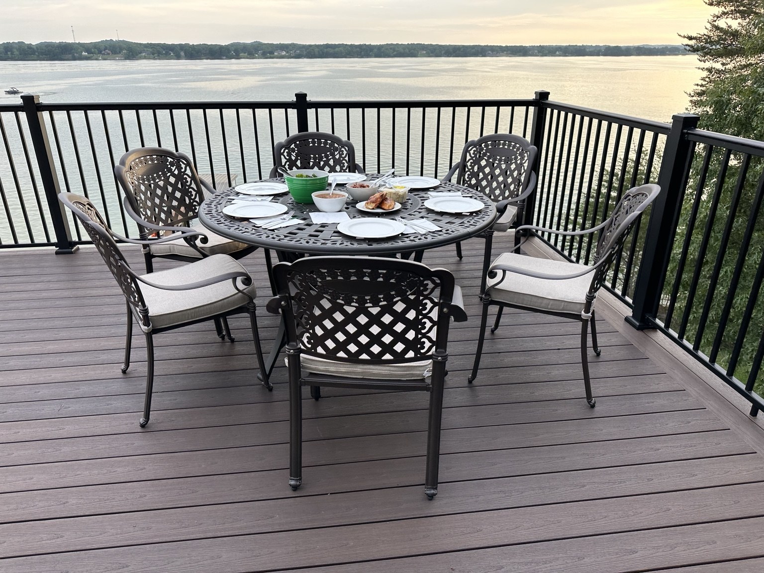 Outdoor dining table set for breakfast on the deck overlooking the lake
