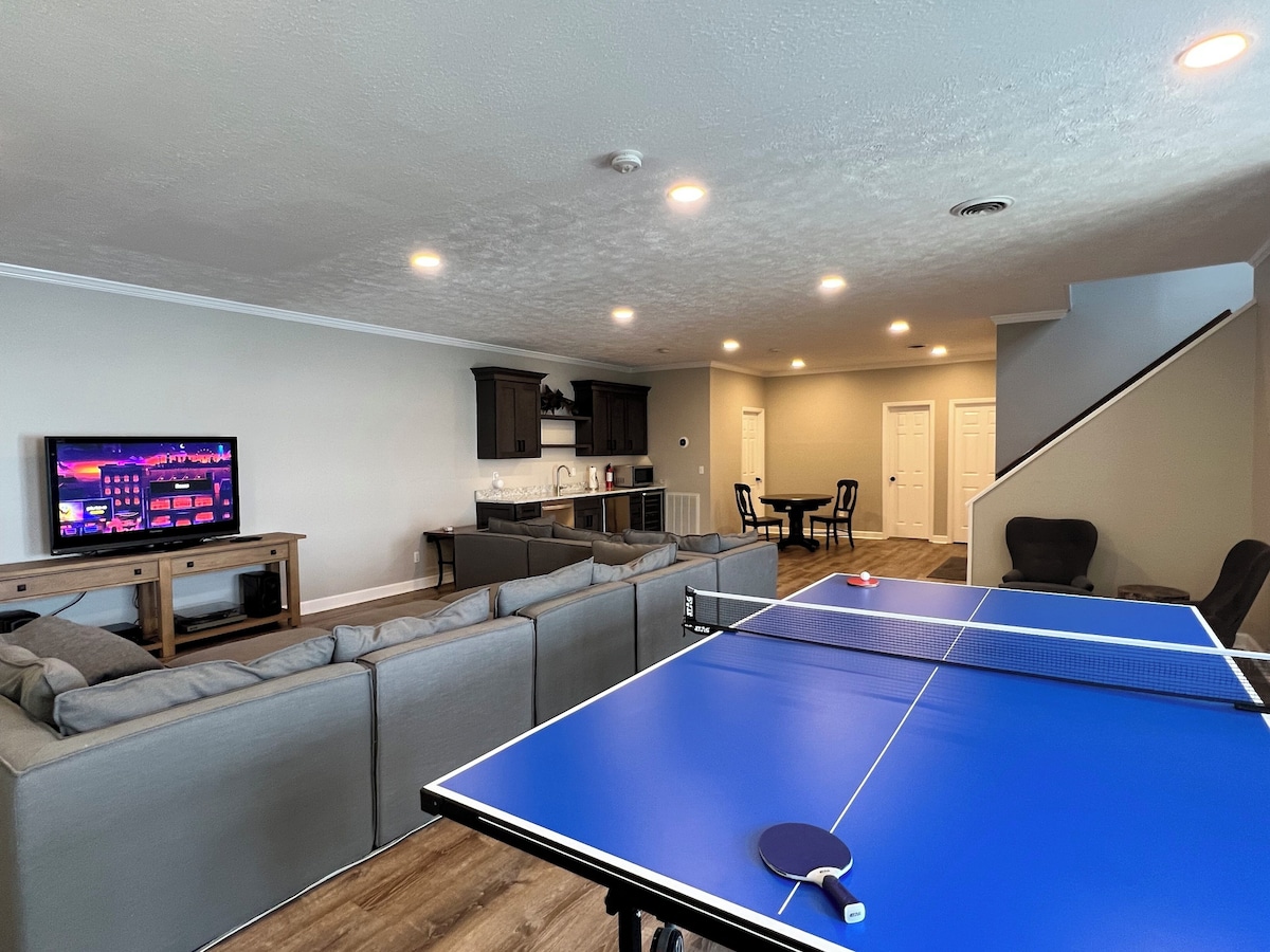 Downstairs recreation room with ping-pong table, sectional seating and wet bar