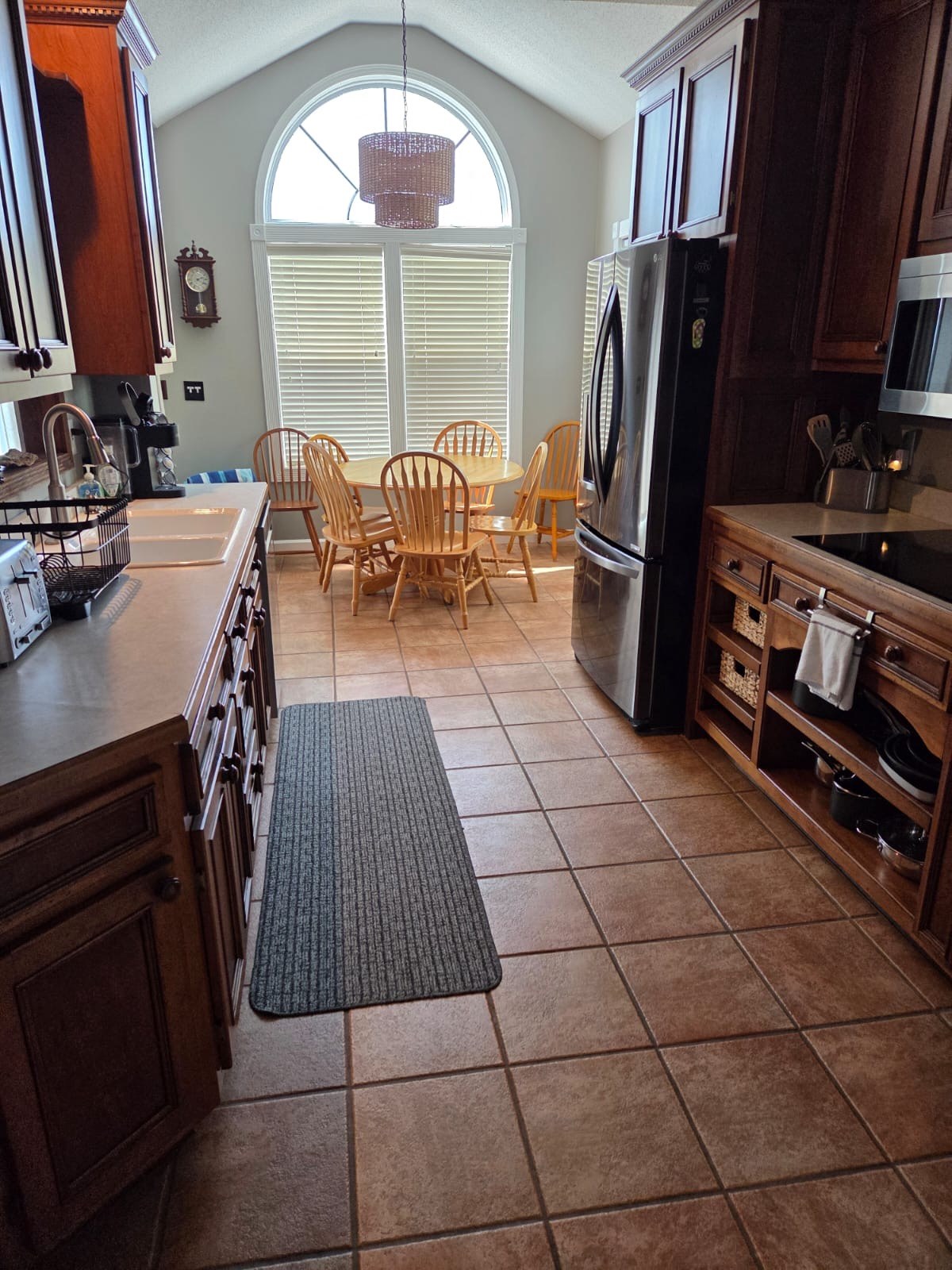 Main kitchen with wood cabinetry, refrigerator and a sunny breakfast nook