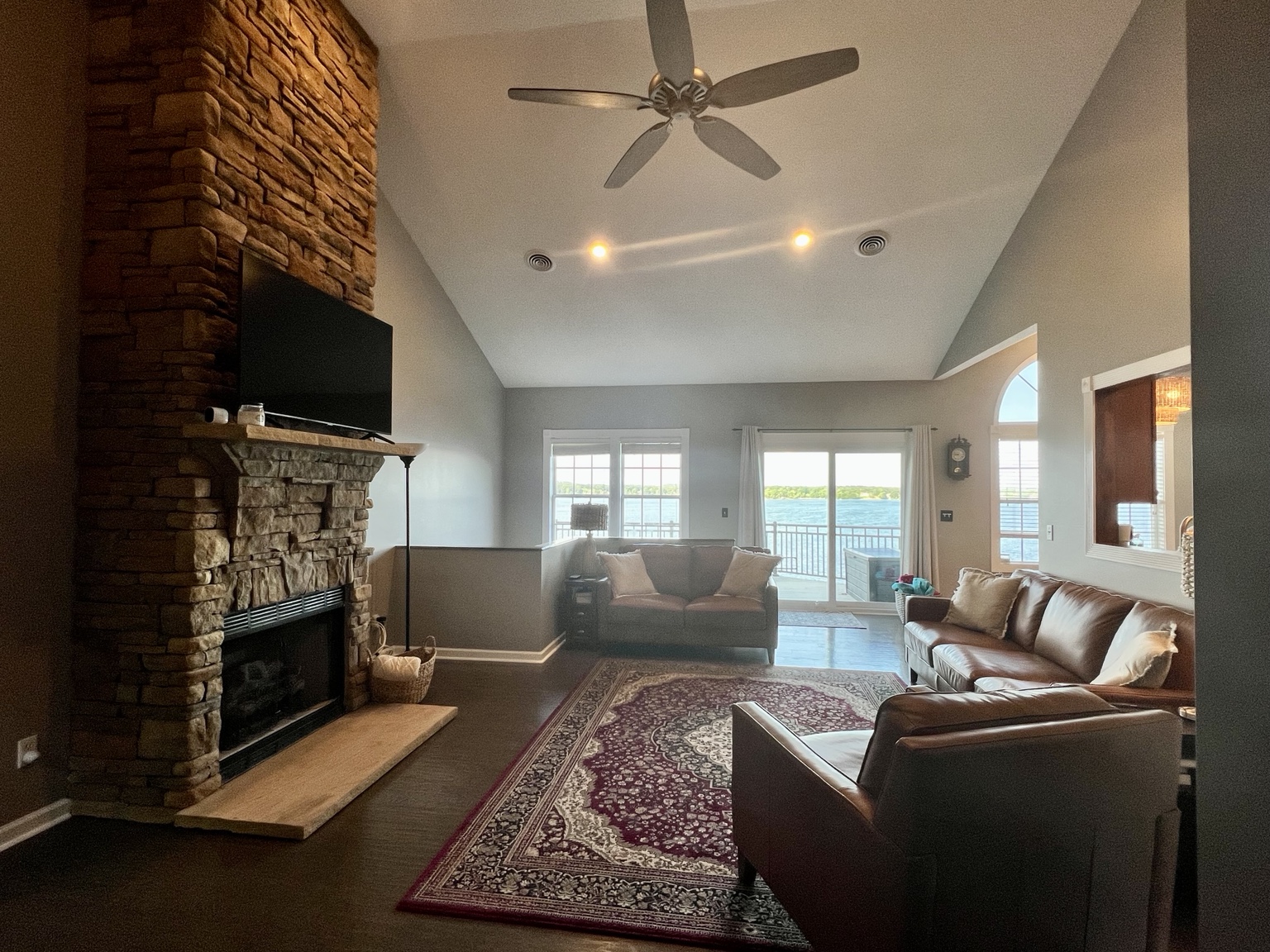 Stone fireplace and leather seating with Douglas Lake visible through the windows